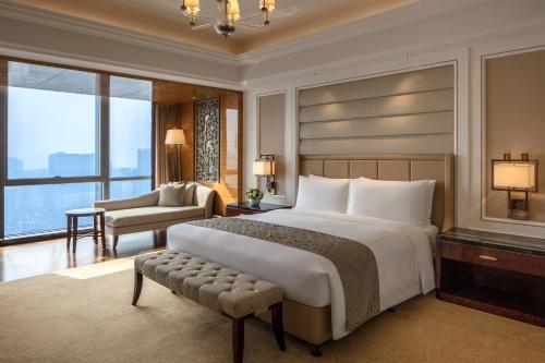 a bedroom with a large bed and a living room at The Ritz-Carlton, Chengdu in Chengdu