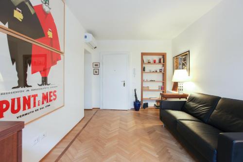 a living room with a couch and a poster on the wall at Romantic Spiga Suite in Milan