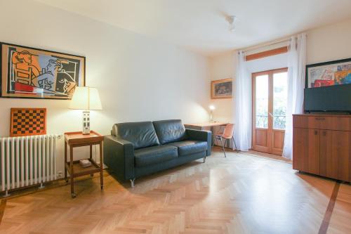 a living room with a couch and a television at Romantic Spiga Suite in Milan