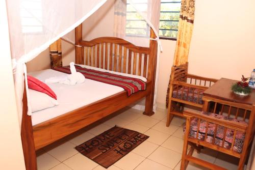 a small bedroom with a bed and a window at Pebbles guesthouse in Diani beach road in Ukunda