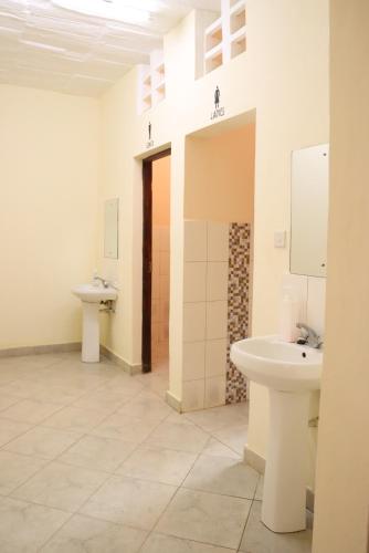 a bathroom with two sinks and a toilet at Pebbles guesthouse in Diani beach road in Ukunda