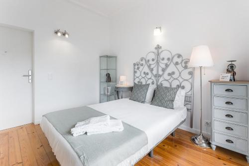 a bedroom with a white bed and a dresser at GuestReady - Gold Leaf in Porto