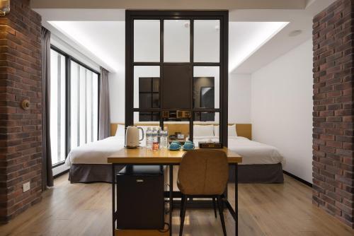 een kamer met een bed en een tafel met stoelen bij BlueSky Hotel in Taichung