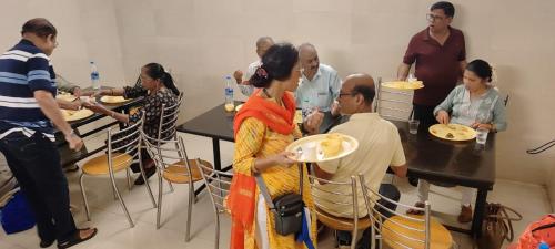 a group of people sitting at a table eating food at Hotel Sri Devi in Kanyakumari