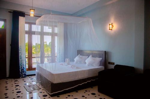 a bedroom with a bed with a canopy at My Resort Yala in Tissamaharama