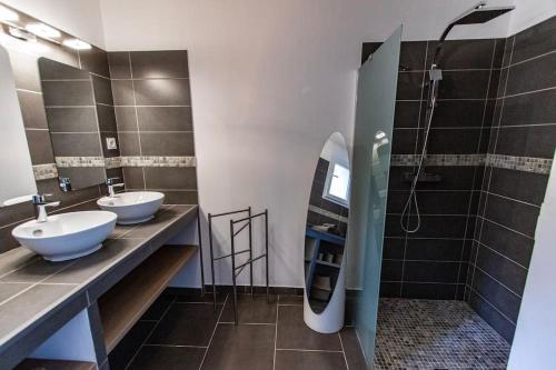 une salle de bain avec deux lavabos et une douche et une planche de surf dans l'établissement Appartement F4 neuf avec jardin et cuisine d'été, à Olmeto
