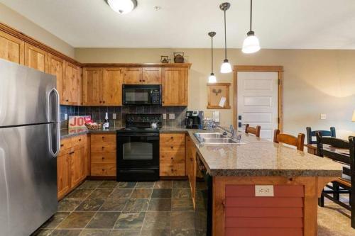 a kitchen with wooden cabinets and a stainless steel refrigerator at Silver Mountain Resort in Kellogg