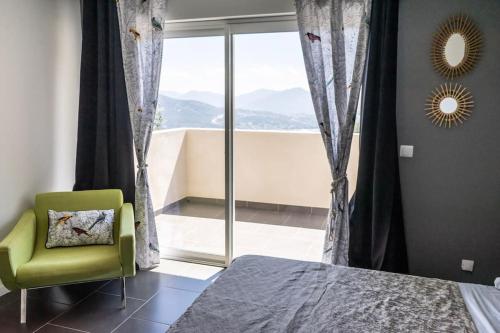 - une chambre avec une chaise verte et une fenêtre dans l'établissement Appartement F4 neuf avec jardin et cuisine d'été, à Olmeto