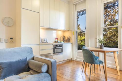 a living room with a couch and a table and a kitchen at Modern 1-Bed Studio near Tramsheds in Sydney