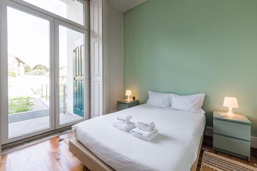 une chambre avec un grand lit blanc et une grande fenêtre dans l'établissement GuestReady - Porto Home GuestHouse, à Porto