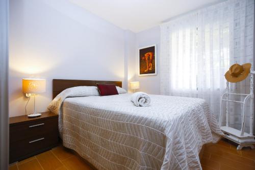 um quarto com uma cama com um cobertor branco em BRISA Planet Costa Dorada em La Pineda