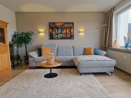 Das kleine Penthouse mit Kamin في باد ساخسا: غرفة معيشة مع أريكة زرقاء وطاولة