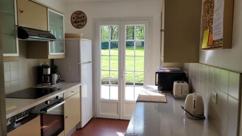 une cuisine avec une porte menant à une cour dans l'établissement Gîte du parc - VALLOIRE SUR CISSE, à Seillac