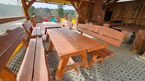 a group of wooden benches sitting inside of a building at Domki Bieszczady Siedlisko Harenda in Czarna