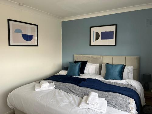 a bedroom with a large bed with blue walls at Harrowby Home in Lincolnshire