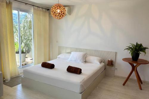 um quarto com uma cama branca com duas toalhas em Duplex design sea view em Papeete