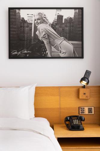 a hotel room with a bed and a phone on a table at BlueSky Hotel in Taichung