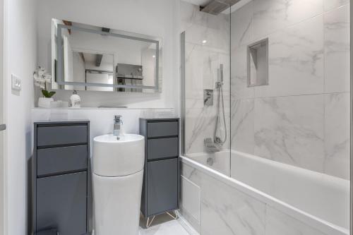 une salle de bain blanche avec un lavabo et une douche dans l'établissement Le Yona Mirabeau - Appartement T3 Atypique situé dans le centre ville historique - proche Rotonde, à Aix-en-Provence