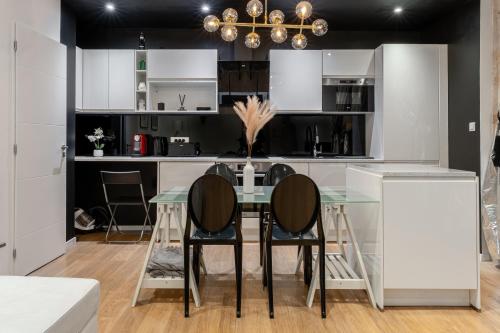 une cuisine avec une table et des chaises en verre dans l'établissement Le Yona Mirabeau - Appartement T3 Atypique situé dans le centre ville historique - proche Rotonde, à Aix-en-Provence