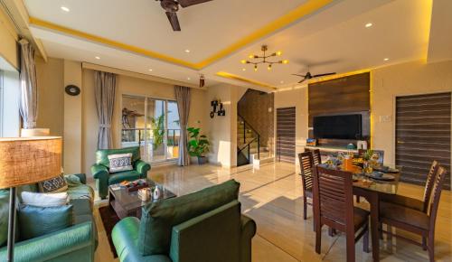 a living room with green furniture and a table at Ekostay Gold - SUCASA VILLA - Games Room - Private Pool in Lonavala