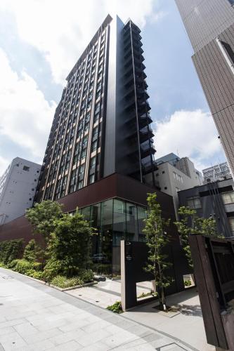 a tall black building with trees in front of it at JR Kyushu Hotel Blossom Shinjuku in Tokyo