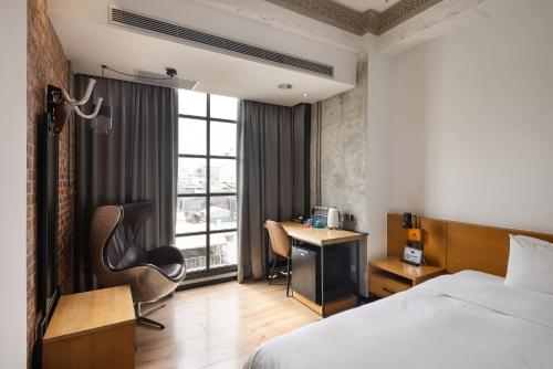 a hotel room with a bed and a desk at BlueSky Hotel in Taichung