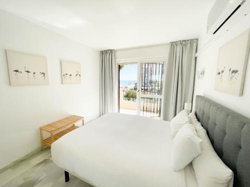 biała sypialnia z łóżkiem i oknem w obiekcie Erisa Terral Apartments w mieście Torremolinos