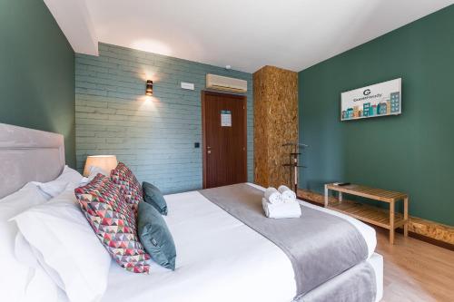 a bedroom with a large white bed and green walls at GuestReady - Portfolio GuestHouse in Porto