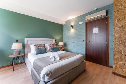 a bedroom with a bed and a green wall at GuestReady - Portfolio GuestHouse in Porto