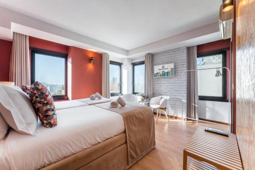 a bedroom with a large bed with red walls and windows at GuestReady - Portfolio GuestHouse in Porto