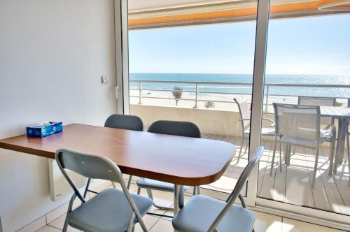 a table and chairs in a room with a view of the ocean at LE PALAIS dETE T4 6-8 115m2 grand standing garage carplug in Canet-en-Roussillon
