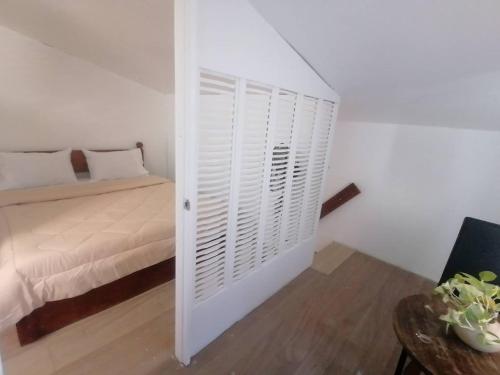 a bedroom with a bed and a white door with a closet at GRIN MCFLY INTERNATIONAL BEACHFRONT GUEST HOUSE in Fuerte