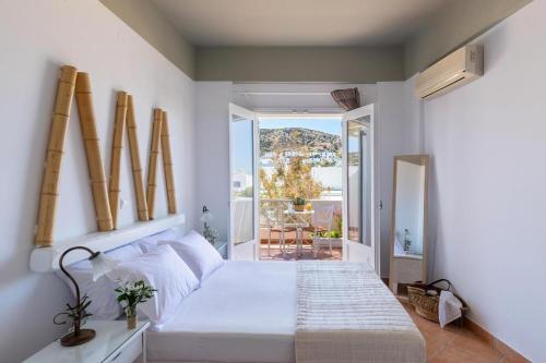 1 dormitorio con 1 cama blanca grande y balcón en Boutique Mare, en Galissas