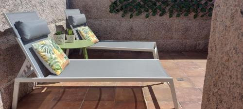 a white bench with pillows on a patio at Stone House Premium Suite in Porriño