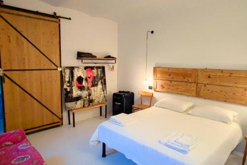 een slaapkamer met een wit bed en een houten deur bij A Casa Da Angelo - Country House PrivatePool & AirCO in Grottammare