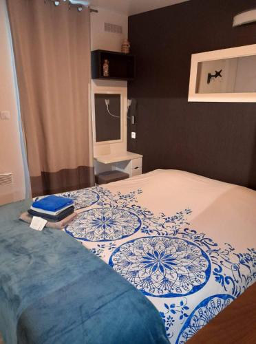 une chambre avec un lit avec une couverture bleue et blanche dans l'établissement Chalet De La Laigne, à Allas-Bocage