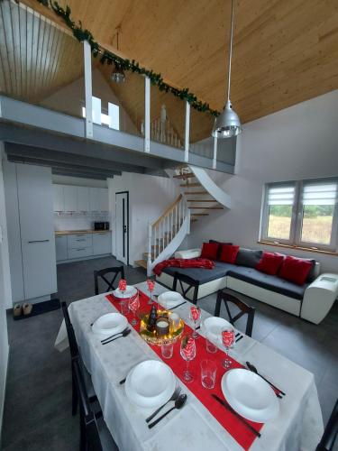 a dining room and living room with a table and chairs at Ranczo pod lasem in Witnica
