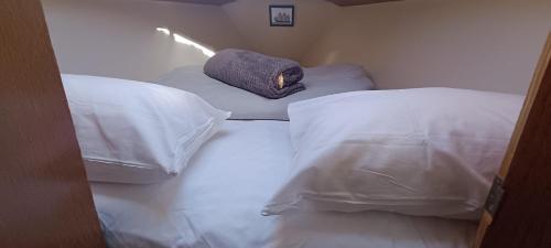 Habitación con 2 camas, sábanas blancas y almohada. en Juangie Home en Valencia