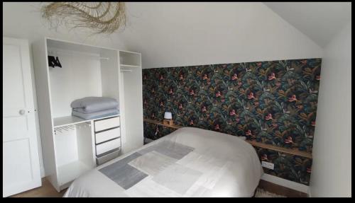 - une chambre avec un lit et un papier peint floral dans l'établissement Superbe t2 lumineux refait à neuf, à Dinard