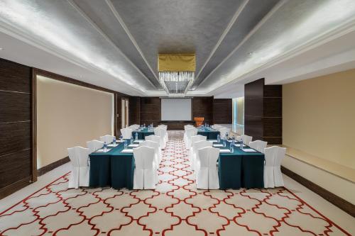 a room with tables and white chairs and a projection screen at Dorsett Chengdu in Chengdu