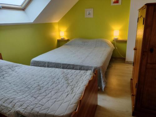 2 camas en una habitación con paredes verdes en GITE DE GROUPE - 14 PERSONNES, en Faye-dʼAnjou