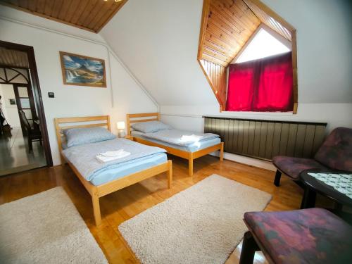 a room with two beds and a window at Oleander Vendégház in Tihany