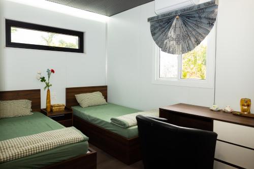 a room with two beds and a desk and an umbrella at Halo Retreat in Hòa Bình