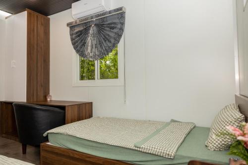 a room with a bed and a desk and a window at Halo Retreat in Hòa Bình
