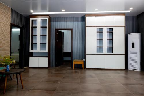 a hallway with white doors and a table at Halo Retreat in Hòa Bình