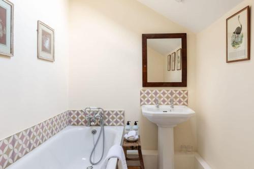 a bathroom with a sink and a tub and a toilet at The Coach House, Wrexham Road in Wrexham