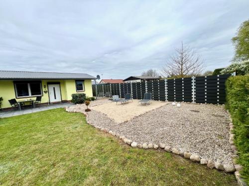a backyard of a house with a fence at Ferienbungalow Muranko am Kiessee in Krugsdorf
