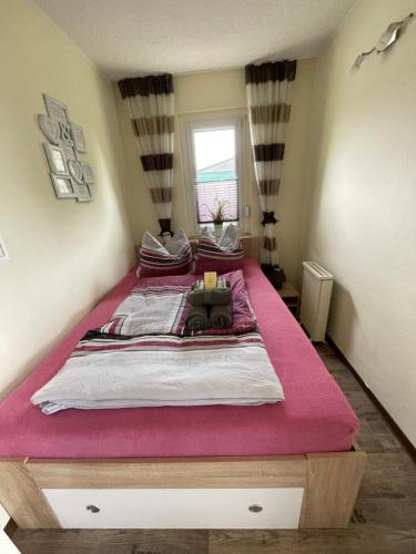 ein Schlafzimmer mit einem großen Bett mit einer rosa Decke in der Unterkunft Ferienbungalow Muranko am Kiessee in Krugsdorf
