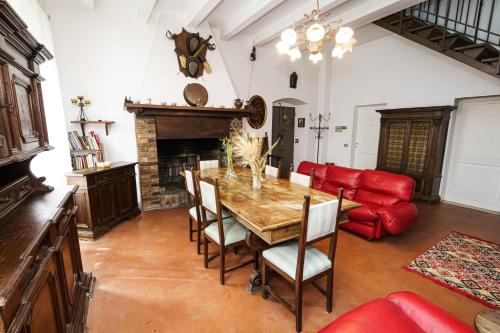 a living room with a wooden table and a red couch at Il Fortino di San Francesco in Collestrada