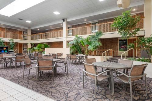 eine Cafeteria mit Tischen, Stühlen und Pflanzen in der Unterkunft Best Western Plus Ramkota Hotel in Sioux Falls